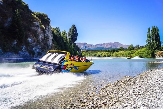 A yellow jet boat running a wide, shallow river