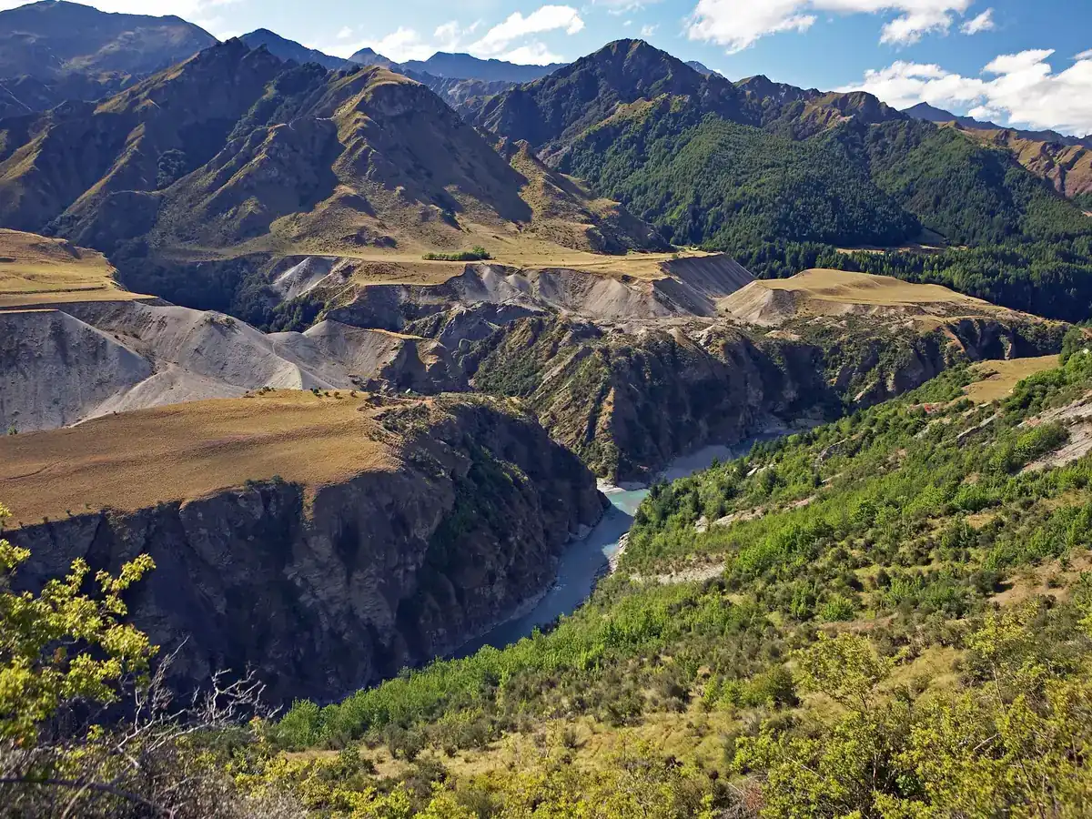 La rivière Shotover serpentant dans une gorge profonde entre des collines d'herbes tussock dorées